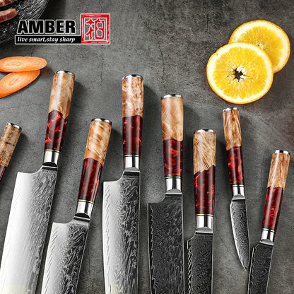 Set aus Damastmessern mit gemaserten Griffen auf grauer Oberfläche, Orangen- und Karottenscheiben, exklusives Küchenzubehör