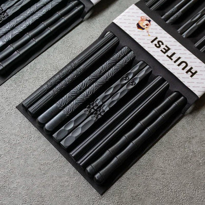 Schwarze Essstäbchen mit verschiedenen Gravuren, stilvolle Küchenutensilien von Kochschein
