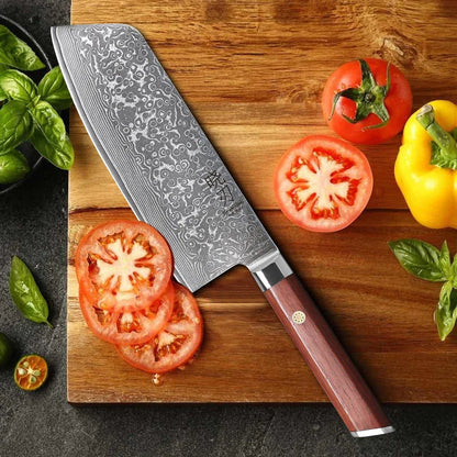 Damast Küchenmesser mit Holzgriff schneidet Tomaten auf Holzbrett, frisches Gemüse daneben