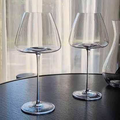 Zwei elegante Weingläser auf dunklem Tisch, moderne Küchenutensilien von Kochschein