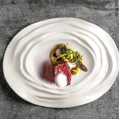 Exklusiver weißer Essteller mit Wellenstruktur und stilvoll angerichtetem Gourmetgericht